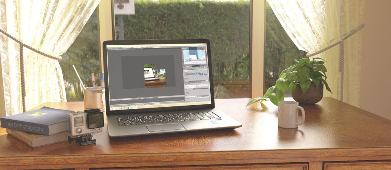 Laptop auf Holztisch am Fenster, mit Pflanze und Kaffeetasse